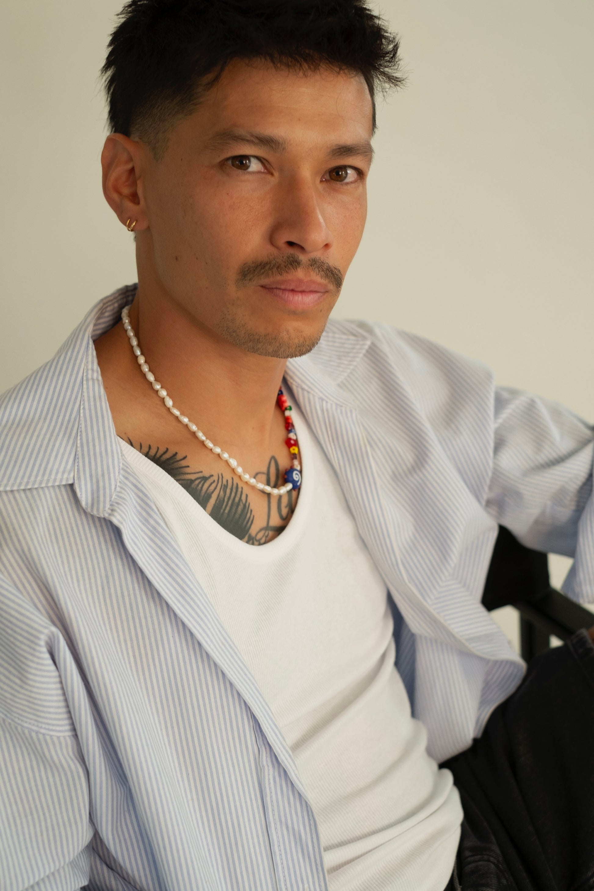 Boy wearing a fashionable outfit and handmade necklace.