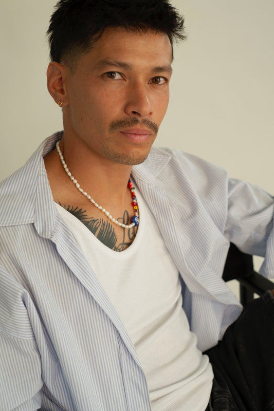 Boy wearing a fashionable outfit and handmade necklace.