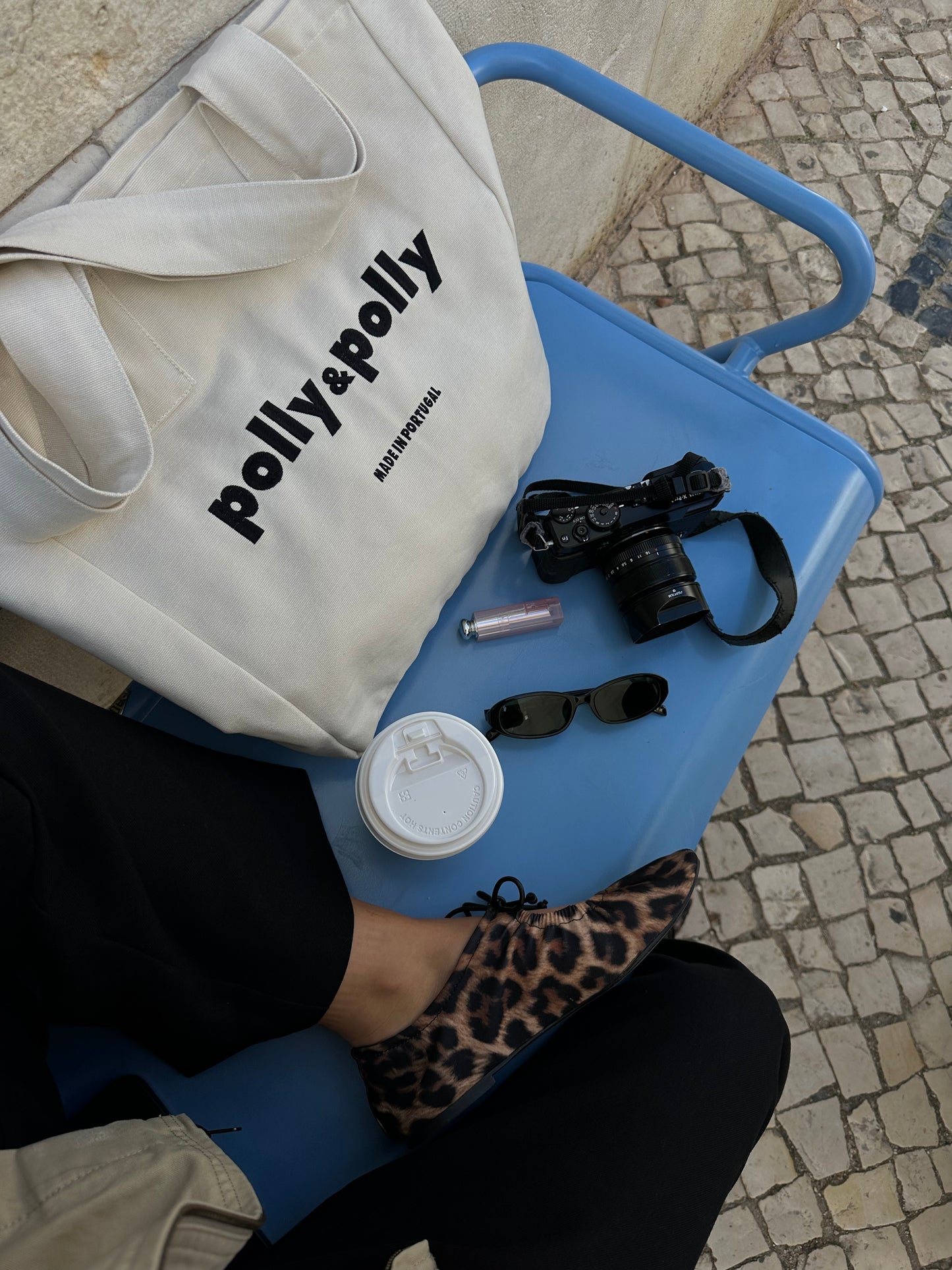 women sitting in a bench with a tote bag